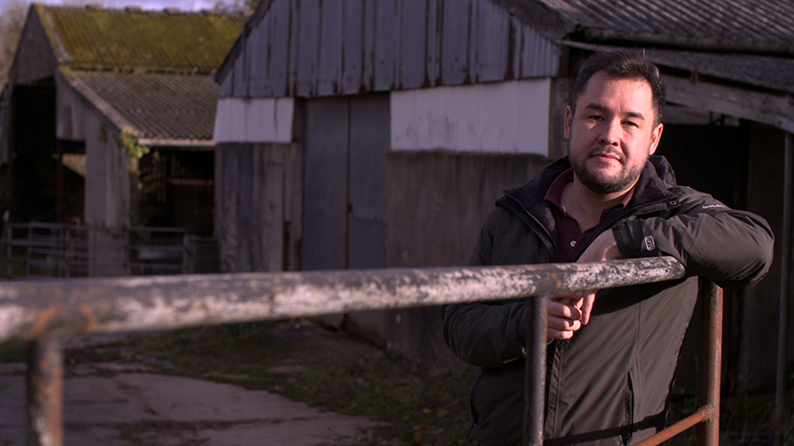 James Wong stands at a farm gate (Credit: BBC)
