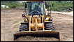 The bodies of victims of last week's Haitian earthquake are pushed by a bulldozer into a mass grave