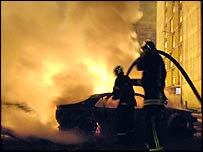 Firemen try to out car on fire