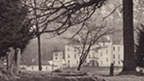 Black and white view of Blair Castle seen through trees from the graveyard of St Bride's Church.