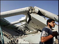 Palestino passa em frente a escola destruída em bombardeio na Faixa de Gaza