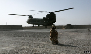 British soldier watches as a Chinook takes off from Camp Delhi, Helmand Province
