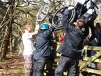 A team try to get the wheelchair over the gate