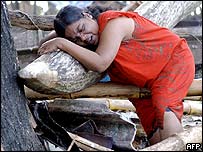 Mulher chora sobre escombros em Galle, Sri Lanka