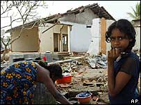 Menina em frente a casa destruída no Sri Lanka
