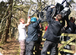 A team try to get a wheelchair over a gate