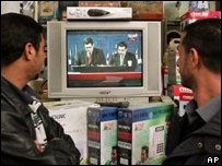 Dois homens observam anúncio do resultado das eleições