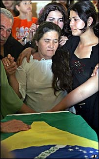Família de Jean diante do caixão com a bandeira do Brasil