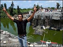 Joven libanes sinaliza perto de ponte destruída em ataque