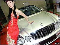 Modelo com carro Mercedes em exposição na China