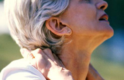 A woman clutching her neck in pain
