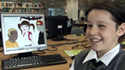 Smiling child in front of computer monitor