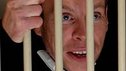 Warwick Davis behind bars in a scene from the trailer for the movie 'ShortFellas'
