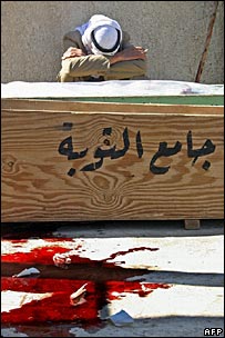Familiar de vítima chora sobre o caixão em Mosul